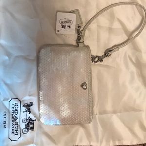 Small off-white sequined Coach wristlet.